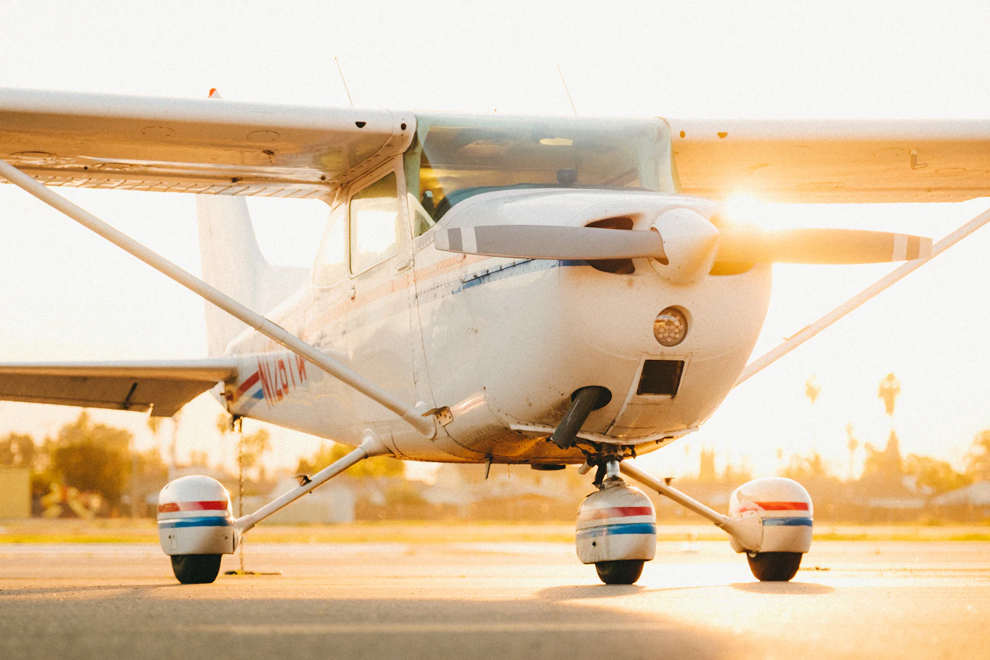 A white Cessna 172 Skyhawk on the ramp at golden hour